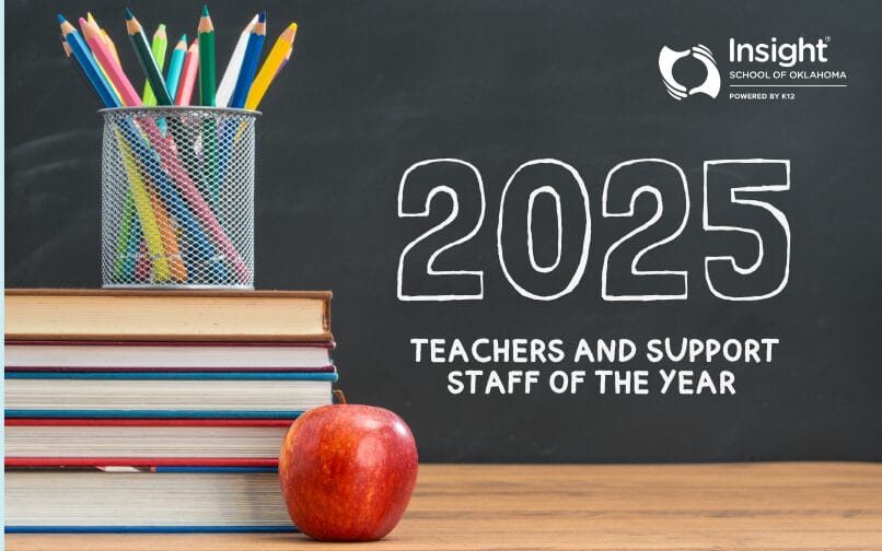 Una pizarra en la que está escrito "2025 Profesores y Personal de Apoyo del Año", junto a una pila de libros, una manzana y una taza de lápices.